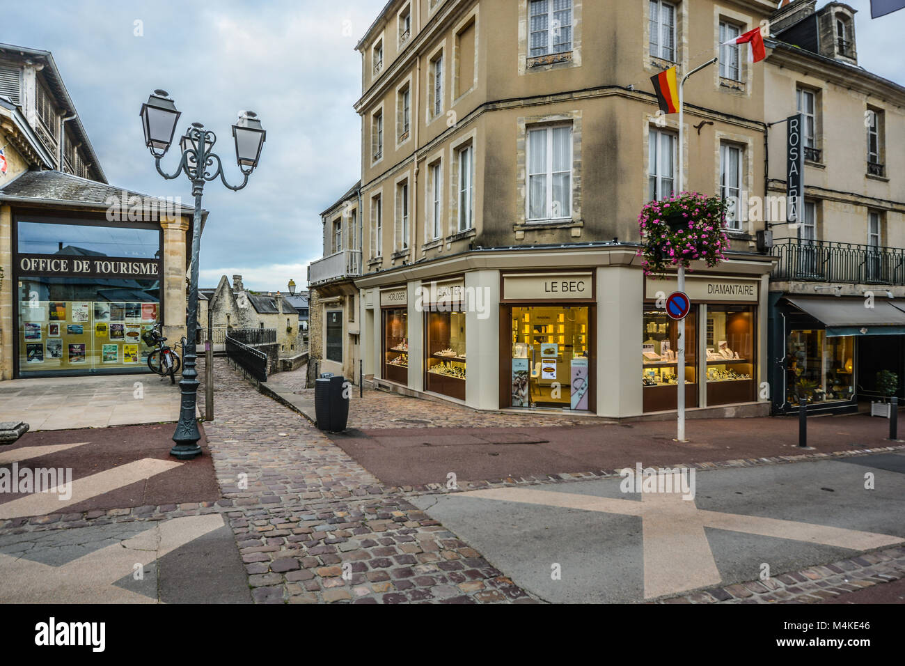 Shops and the office de tourisme along the main road through the medieval town of Bayeux in the Normandy region of France Stock Photo