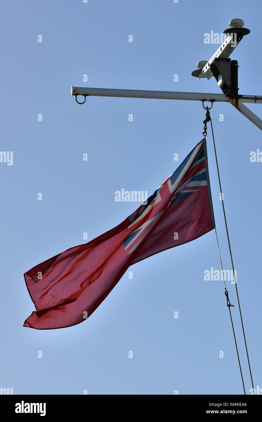the red ensign flag flying from the main mast of a passenger ship. the red duster ensign or flag. Stock Photo