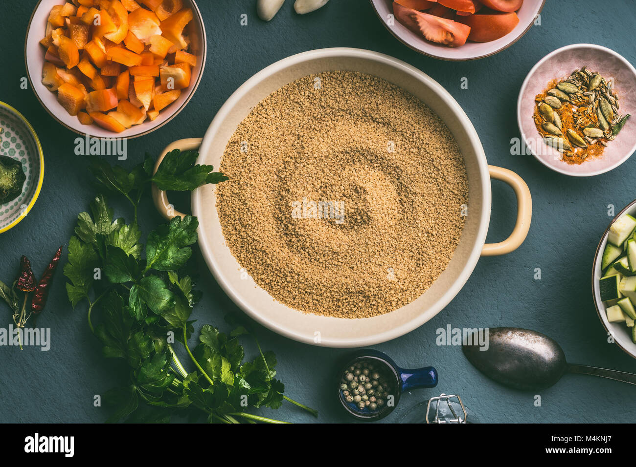 Couscous pot with cut vegetables ingredients in bowls , top view