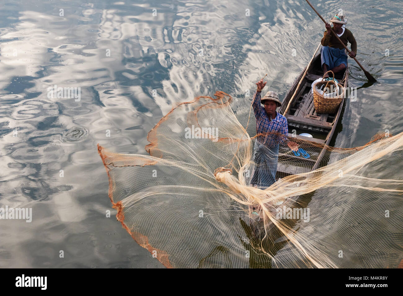 Fishermen using fishing net to catch fish at TaugThaMan Lake below U Bein  Bridge at Amarapura, near Mandalay, Myanmar, Burma Stock Photo - Alamy