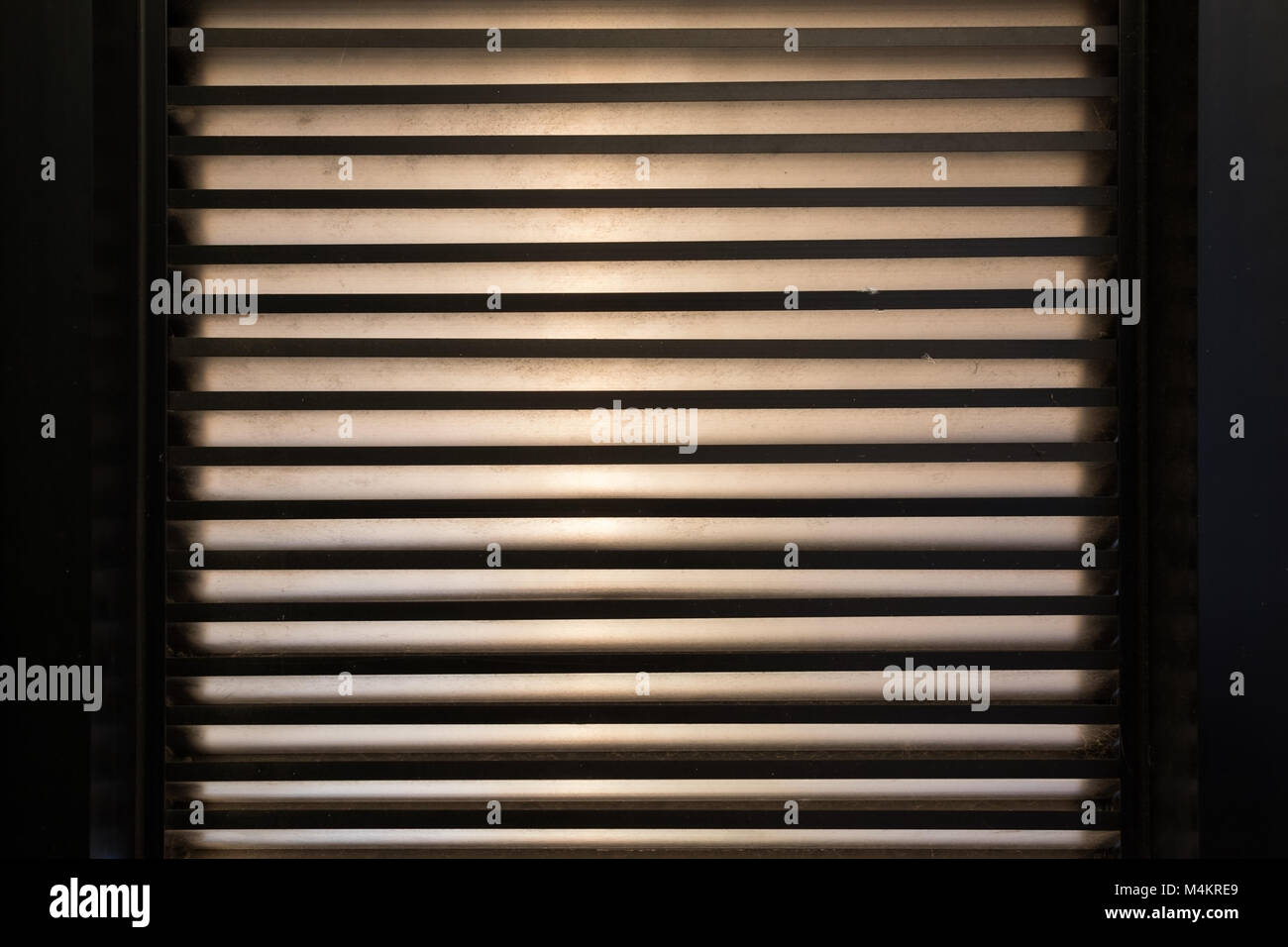 jalousie on window. Stripes of light. It is dark inside Stock Photo