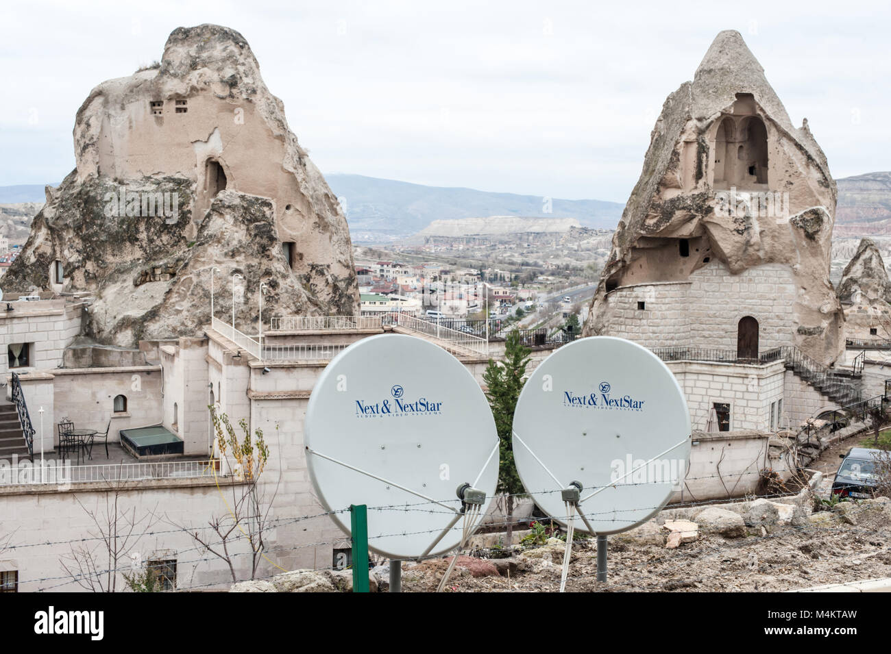 Ancient carved rock houses with satellite dishes in Cappadocia, Turkey Stock Photo
