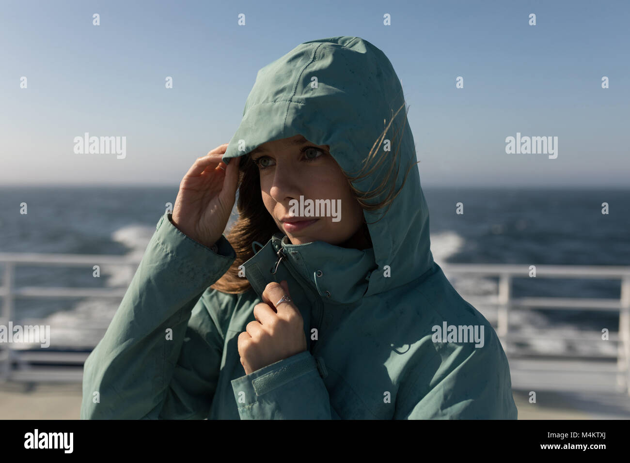 Woman in hoodie standing on cruise ship Stock Photo