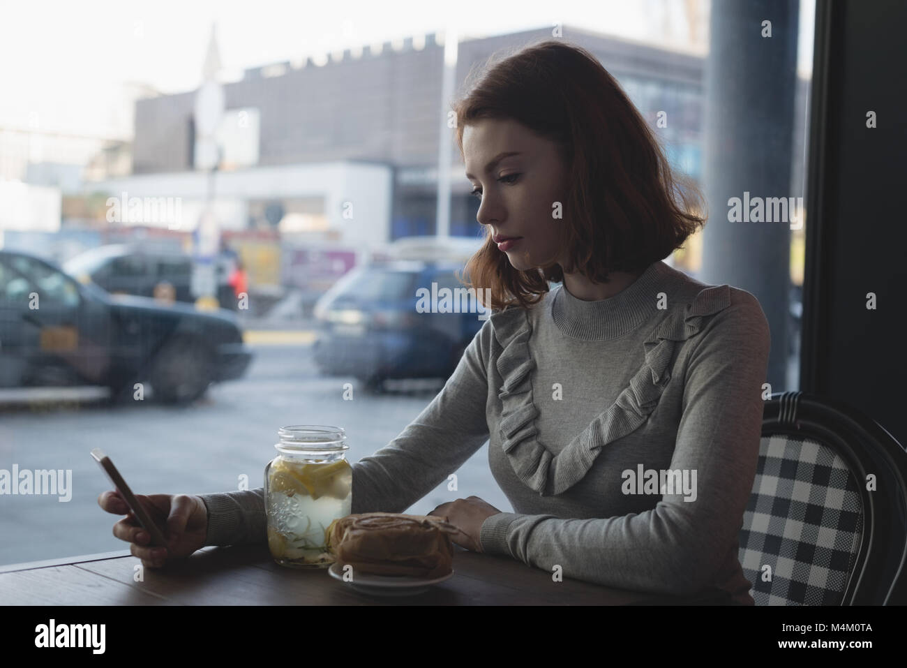 Woman using mobile phone in cafe Stock Photo