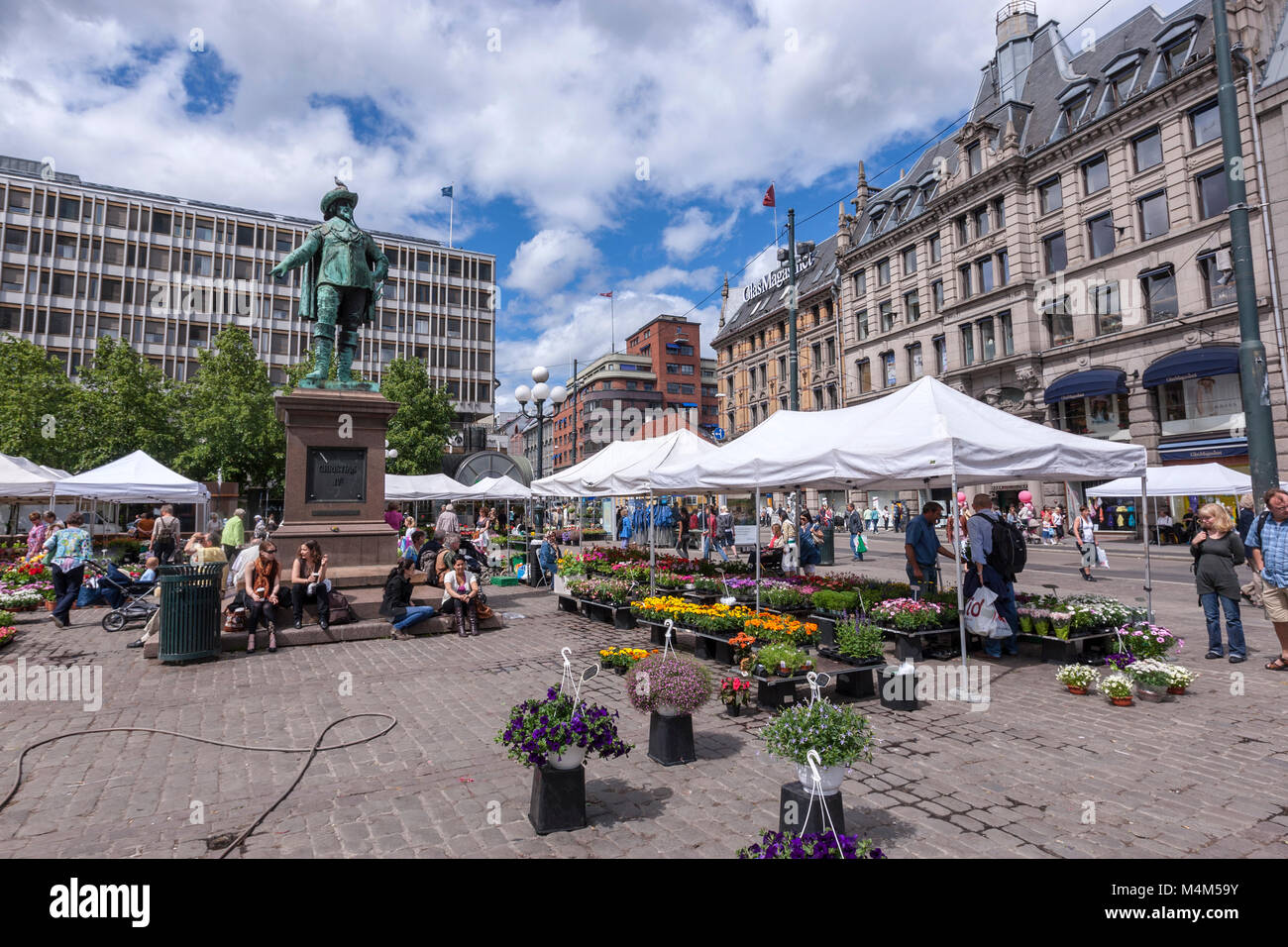 Bronze statue of Christian IV, by artist Carl Ludvig Jacobsen. in Stortorvet with people seating in the statue base, Oslo, Norway Stock Photo