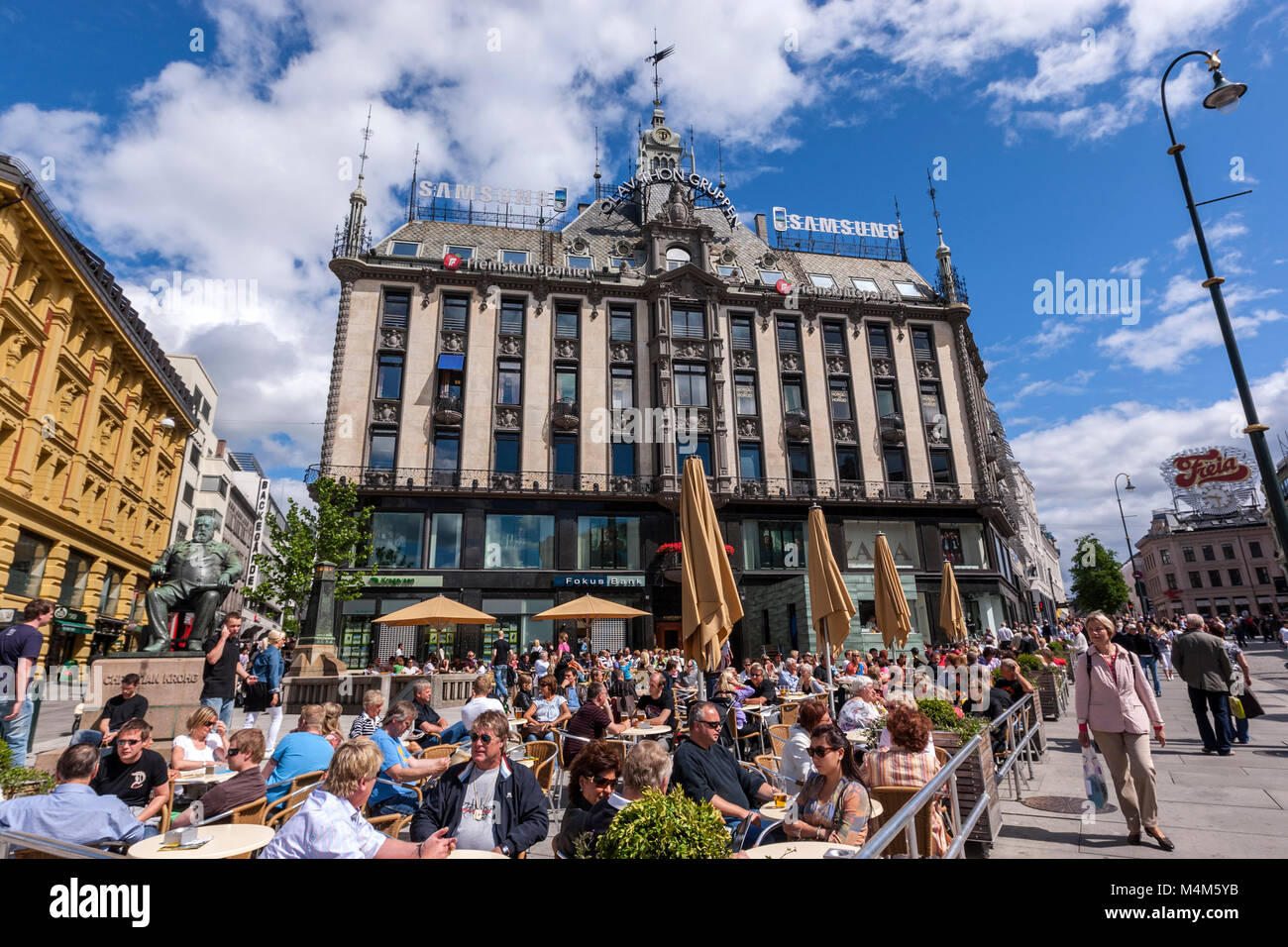 Sunny summer day with terrace full of people in front of Olav Thon Gruppen house, Karl Johans gate, Oslo, Norway Stock Photo
