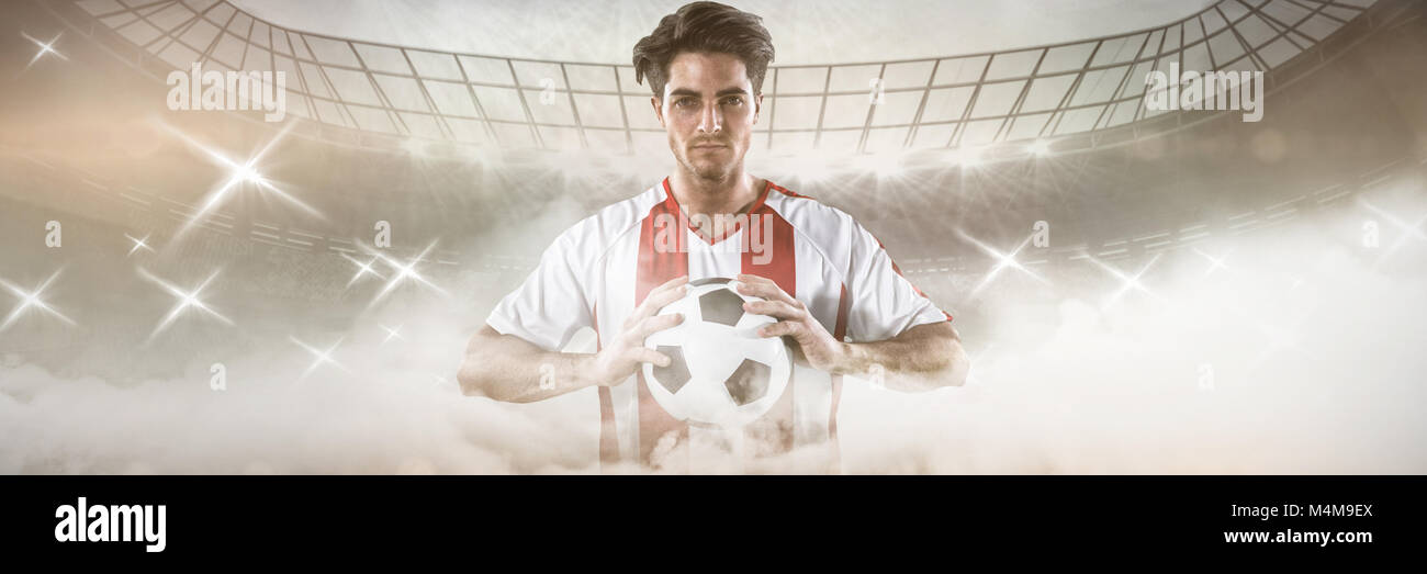 Composite image of portrait of confident athlete holding football Stock Photo