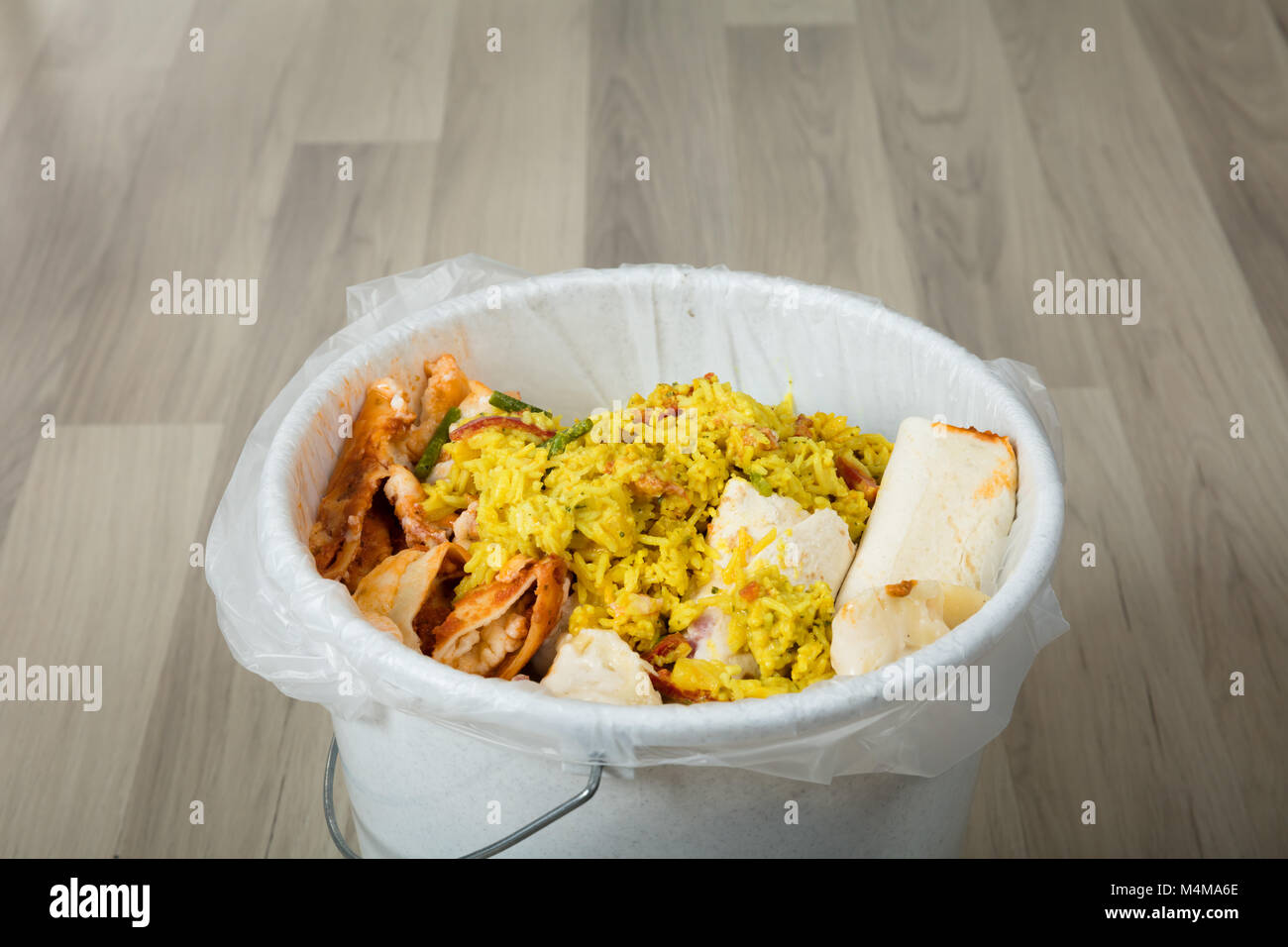 Close-up Of White Trash Bin Covered With Leftover Food Stock Photo