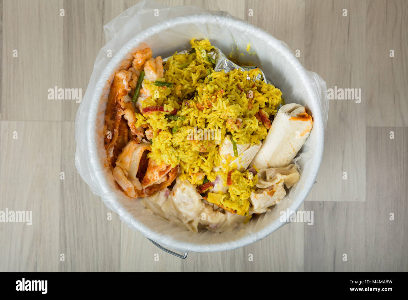Close-up Of White Trash Bin Covered With Leftover Food Stock Photo
