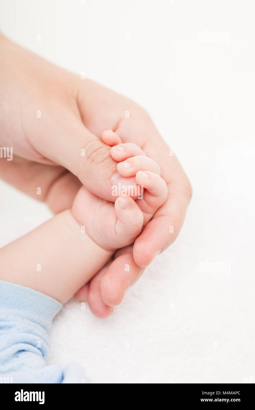 Mother holding newborn baby child little hand with small fingers Stock Photo