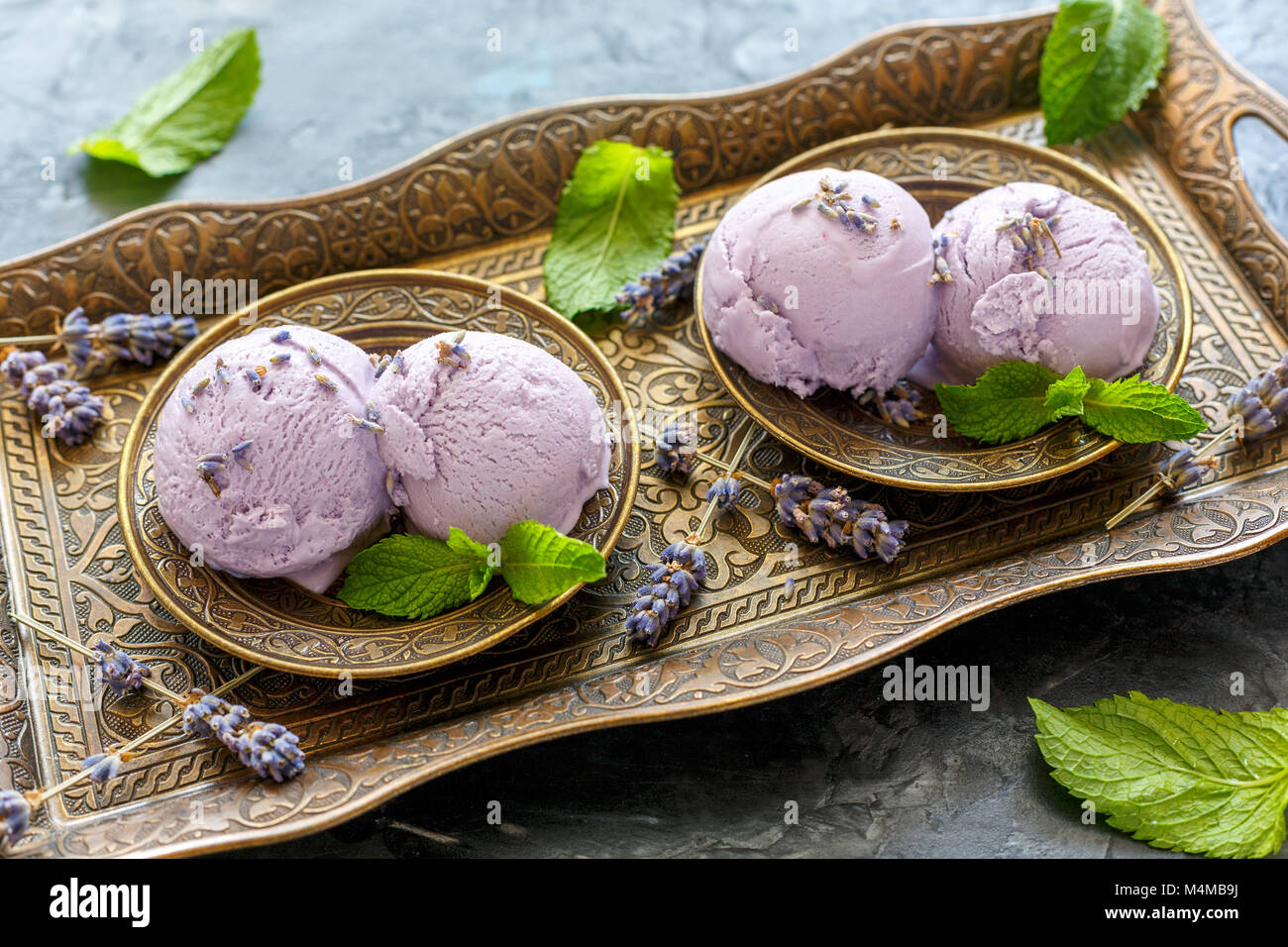 Balls of lavender ice cream and mint leaves. Stock Photo