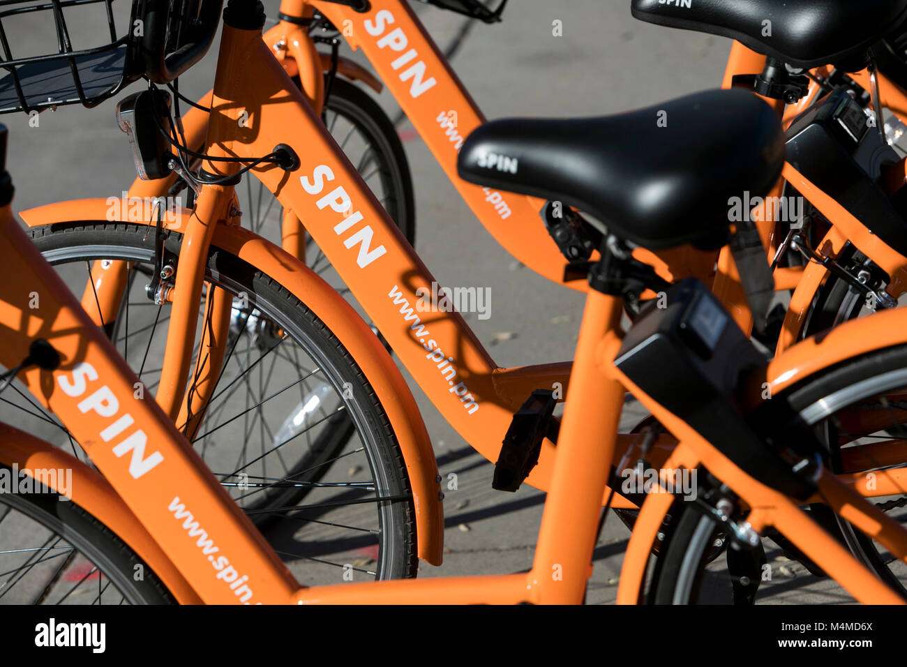 A row of Spin dock-less bicycle-sharing bikes in Tempe, Arizona, on February 3, 2018. Stock Photo
