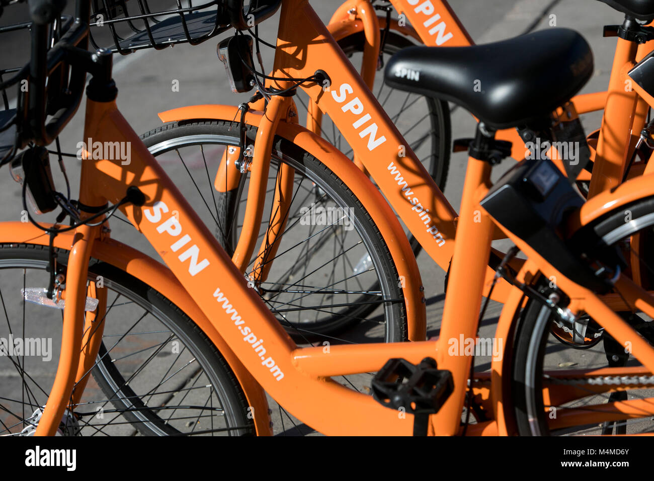 A row of Spin dock-less bicycle-sharing bikes in Tempe, Arizona, on February 3, 2018. Stock Photo