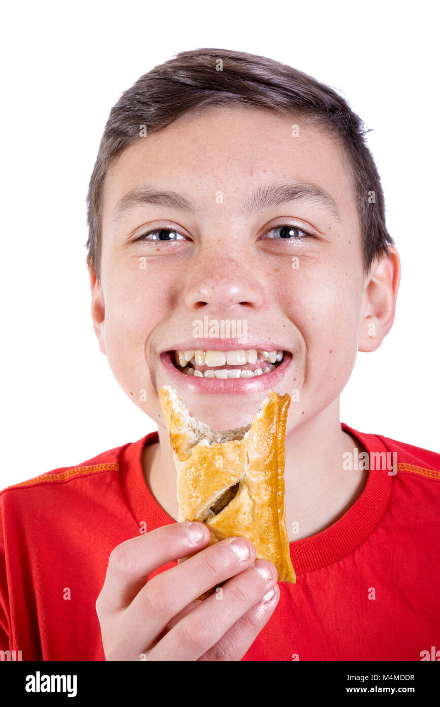 Young caucasian teenage boy eating a sausage roll Stock Photo