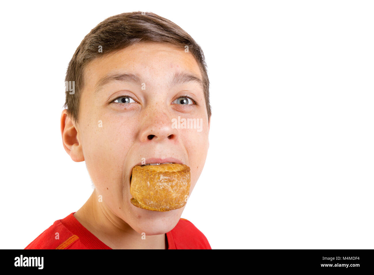 young-caucasian-teenage-boy-eating-a-pork-pie-M4MDF4.jpg