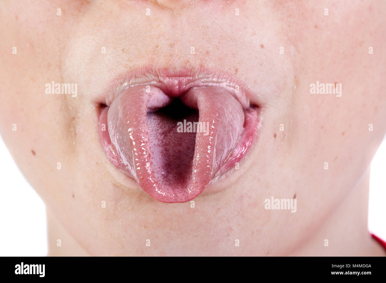 Close up of a young caucasian teenage boy's face rolling his tongue Stock Photo