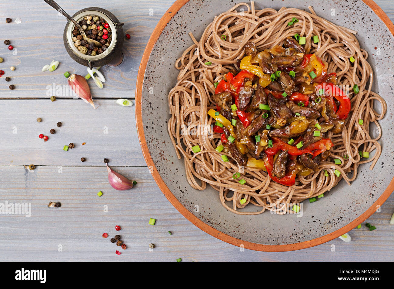 Stir fry from chicken hearts, paprika, onions and buckwheat noodles