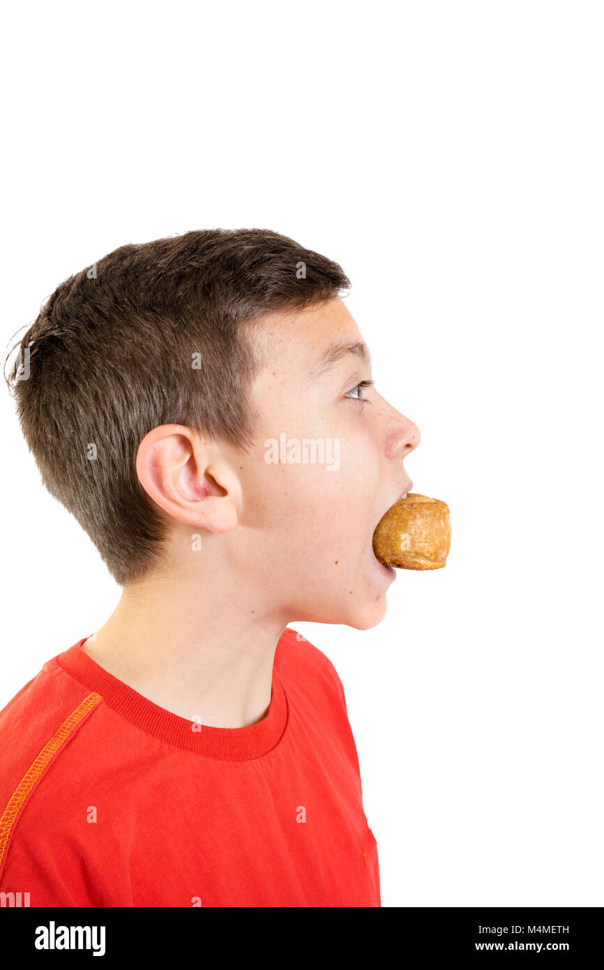 Young caucasian teenage boy eating a pork pie Stock Photo