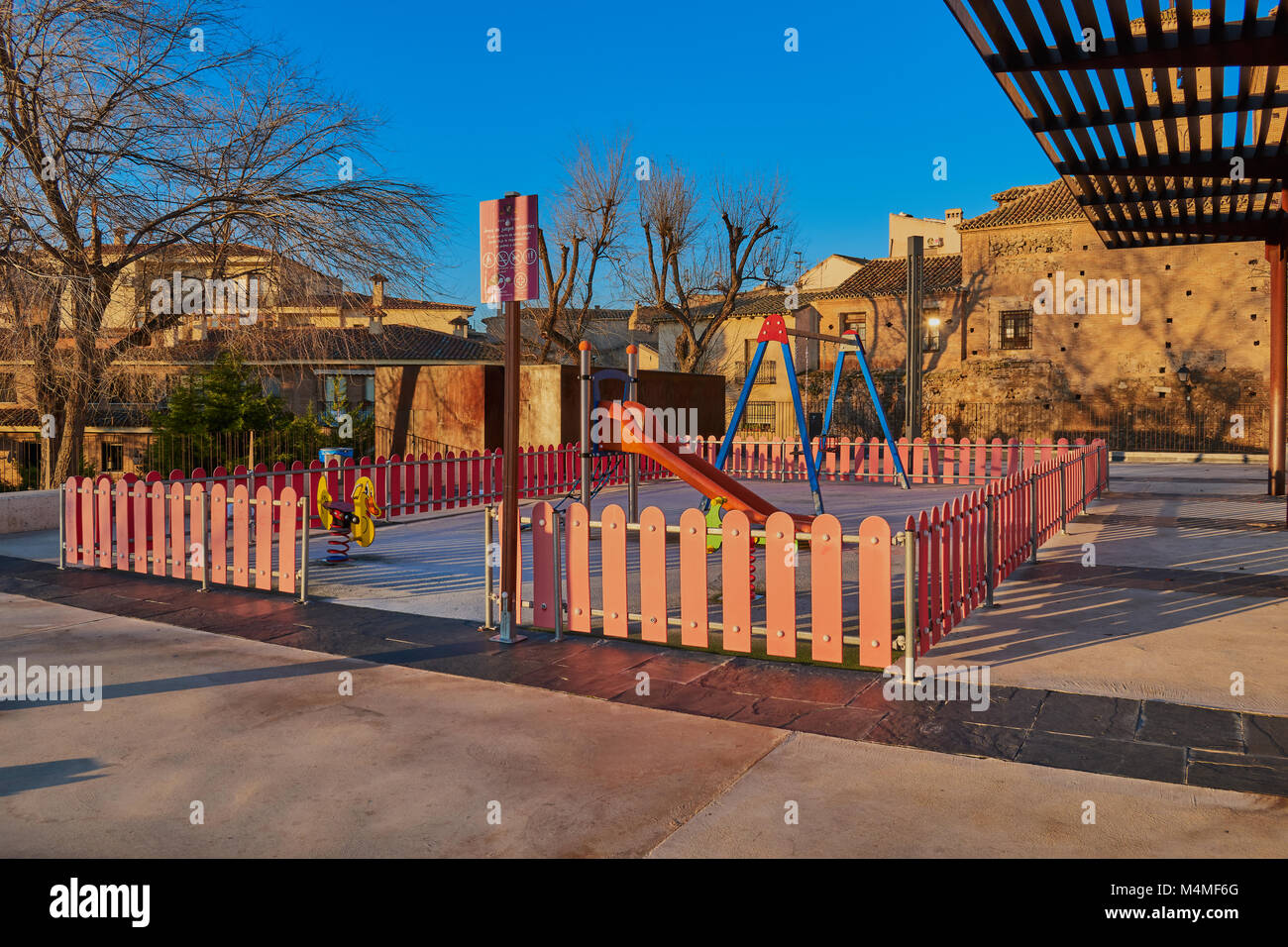 Children's playground with swings and slides dawning in Corralillo de San Miguel in Toledo, Spain Stock Photo