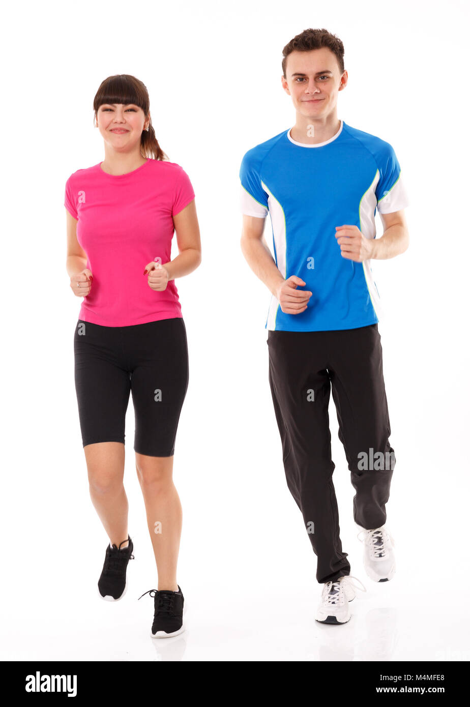 Athletic couple of teenagers running, full length over white background Stock Photo
