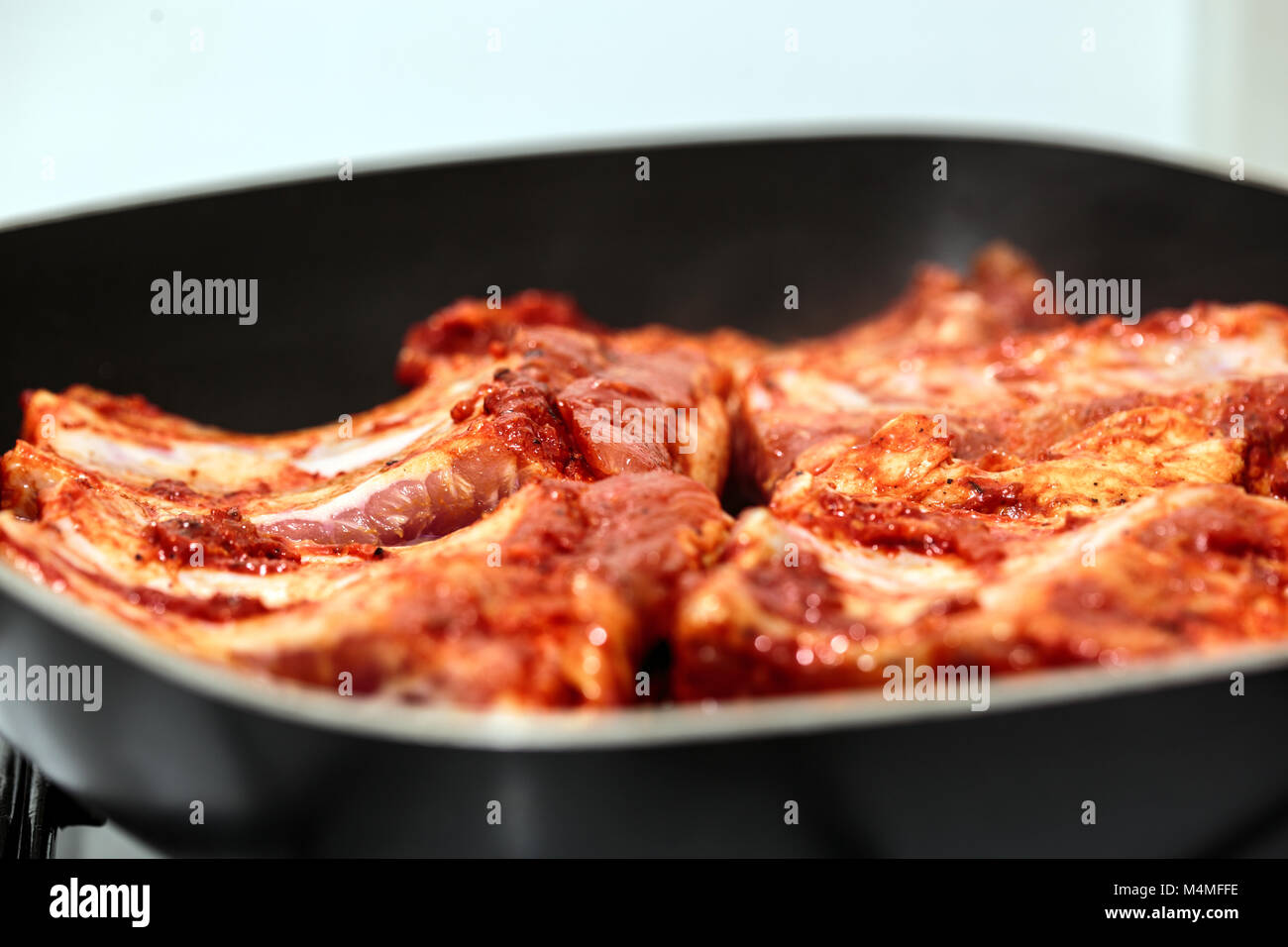 Seasoned pork ribs in the frying pan, cooking Stock Photo Alamy