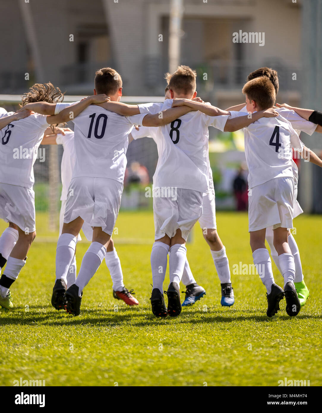 Happy Soccer Players. Happy Boys Winning Soccer Match. Young Successful Soccer Football Players Dancing Together on the Pitch. Stock Photo