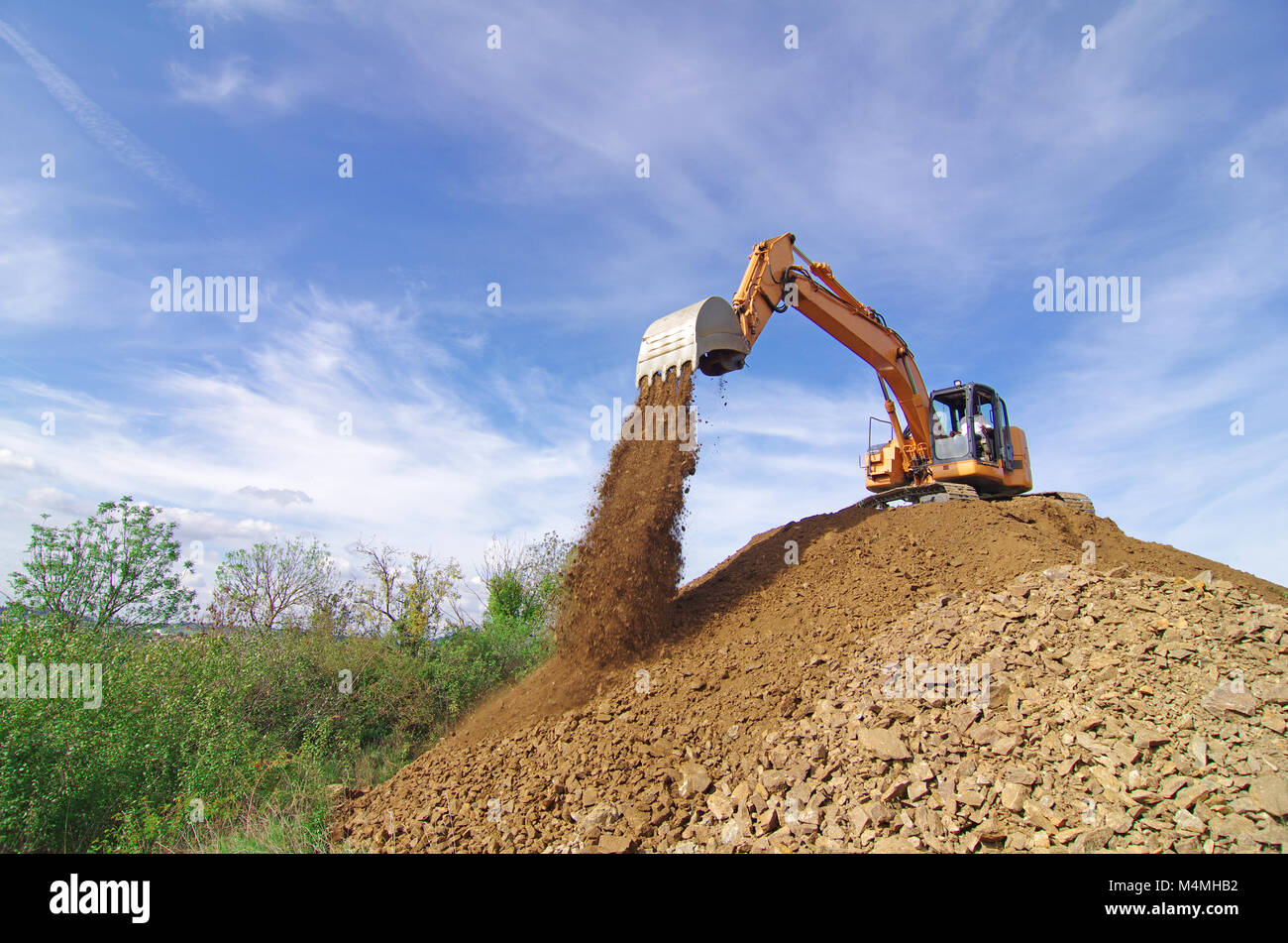 Excavator in action during earth moving works Stock Photo