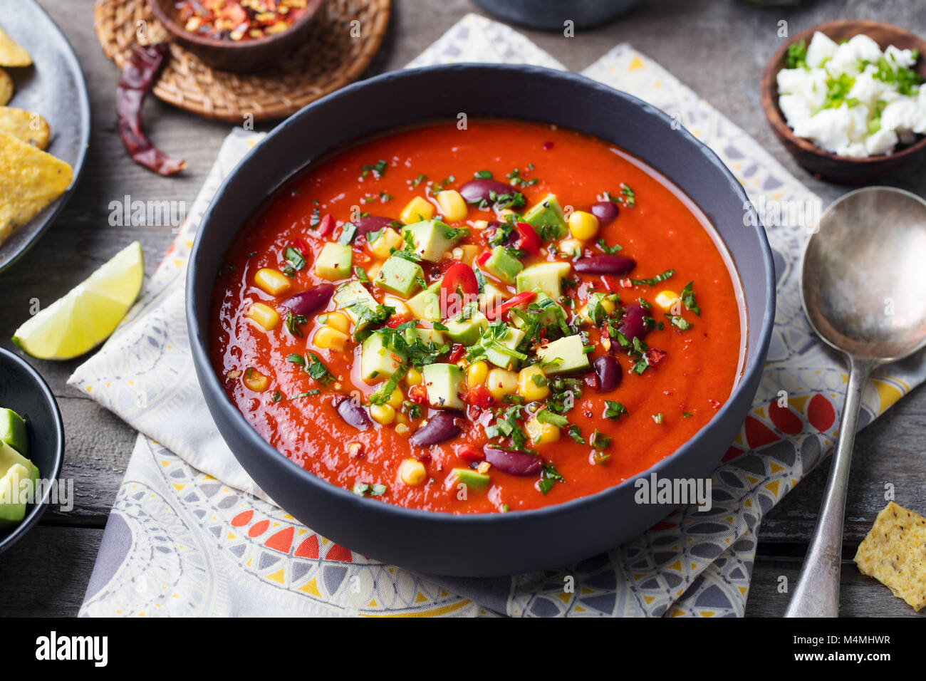 Mexican tomato, bean, bell pepper soup in black bowl Stock Photo