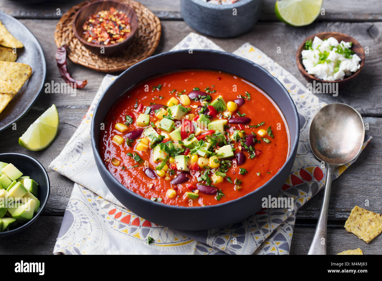 Mexican tomato, bean, bell pepper soup in black bowl Stock Photo