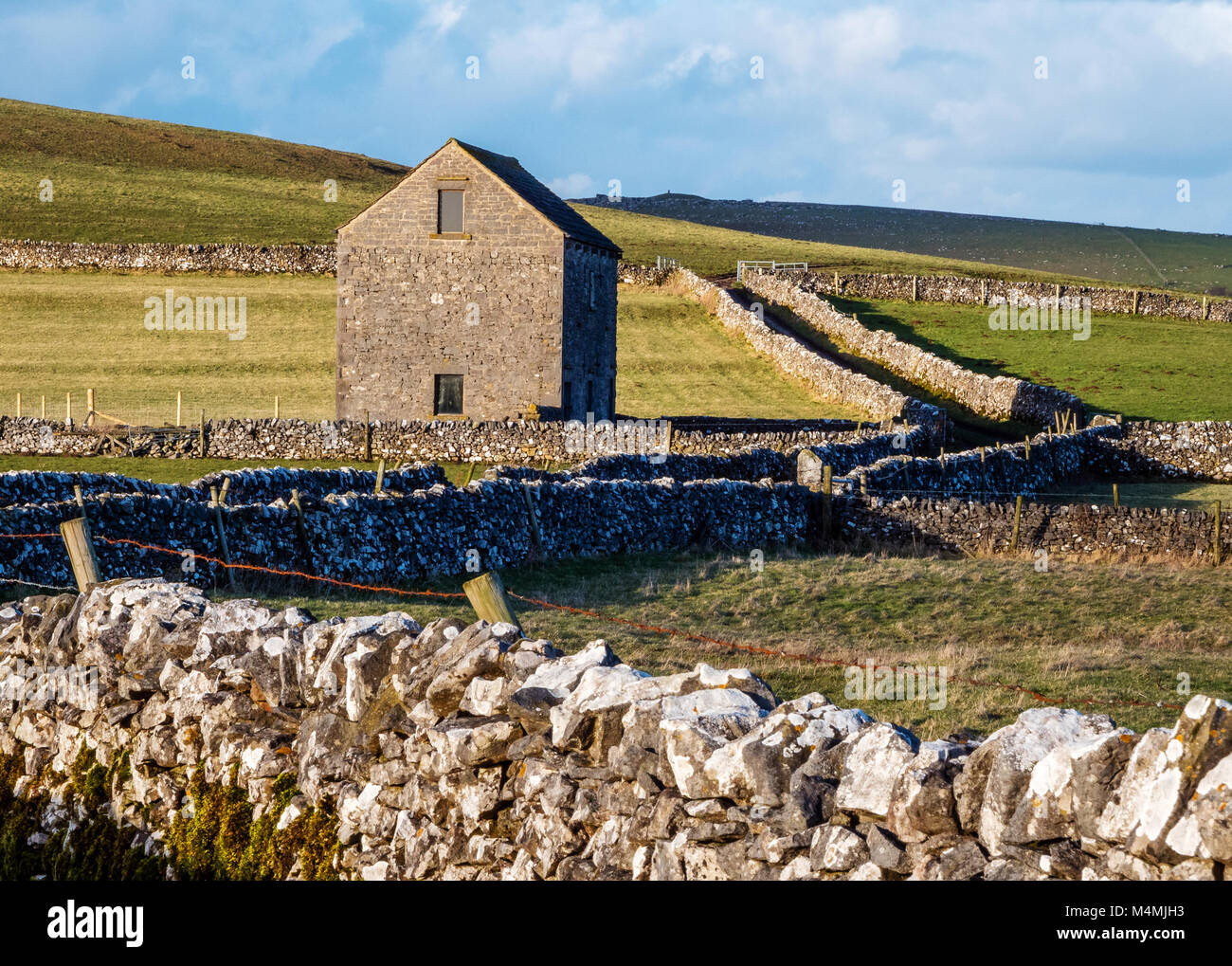 Field barn beside a green lane with dry stone walls near Alstonefield in the White Peak of Staffordshire UK Stock Photo
