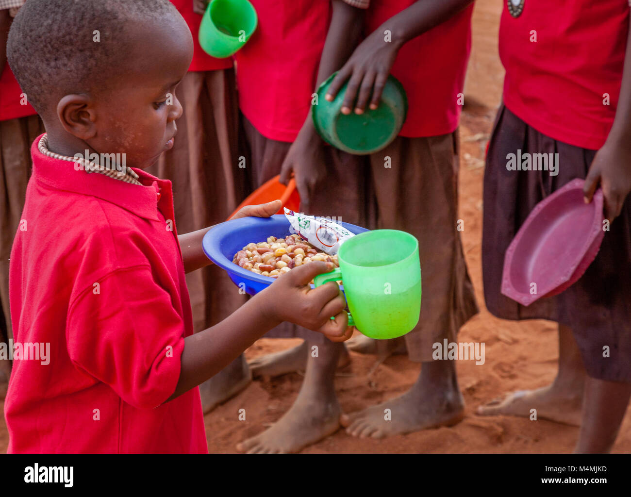 School child with his  lunchtime stew made with beans maize and onions at Kileva Primary School near Voi in Southern Kenya Stock Photo