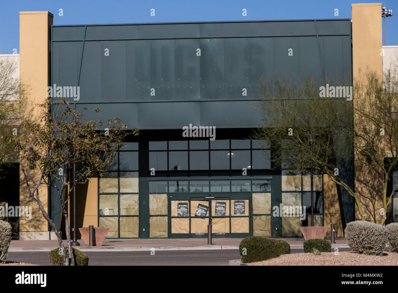The faded outline of a logo sign outside of a now closed Dick's