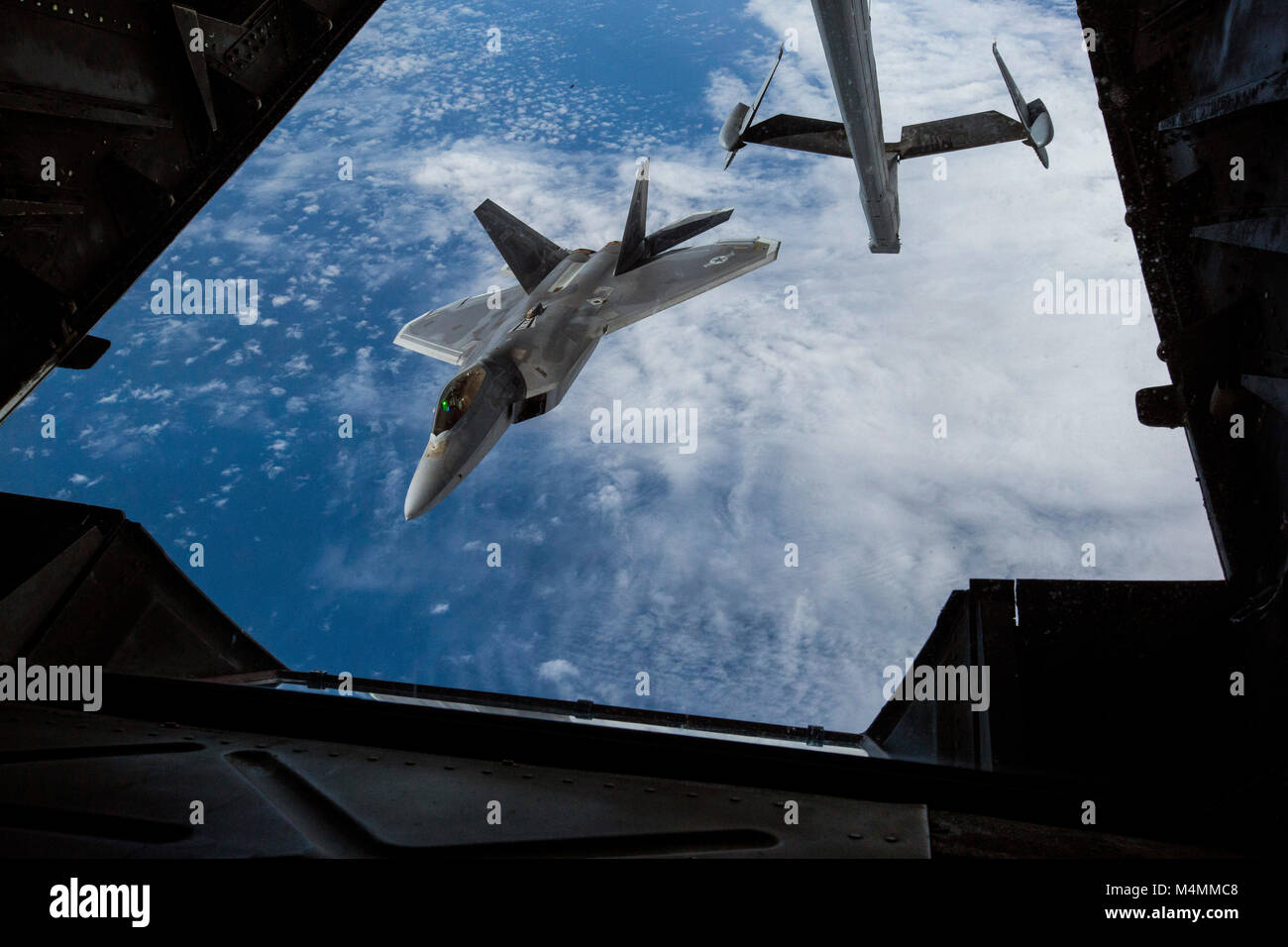 A U.S Air Force F-22 Raptor with the 1st Fighter Wing, Joint Base Langley-Eustis, Va., moves away after being refueled by a KC-10 Extender with the 78th Air Refueling Squadron, 514th Air Mobility Wing, over the Atlantic Ocean, Feb. 14, 2018. The 514th is an Air Force Reserve Command unit located at Joint Base McGuire-Dix-Lakehurst, N.J. (U.S. Air Force photo by Master Sgt. Mark C. Olsen) Stock Photo