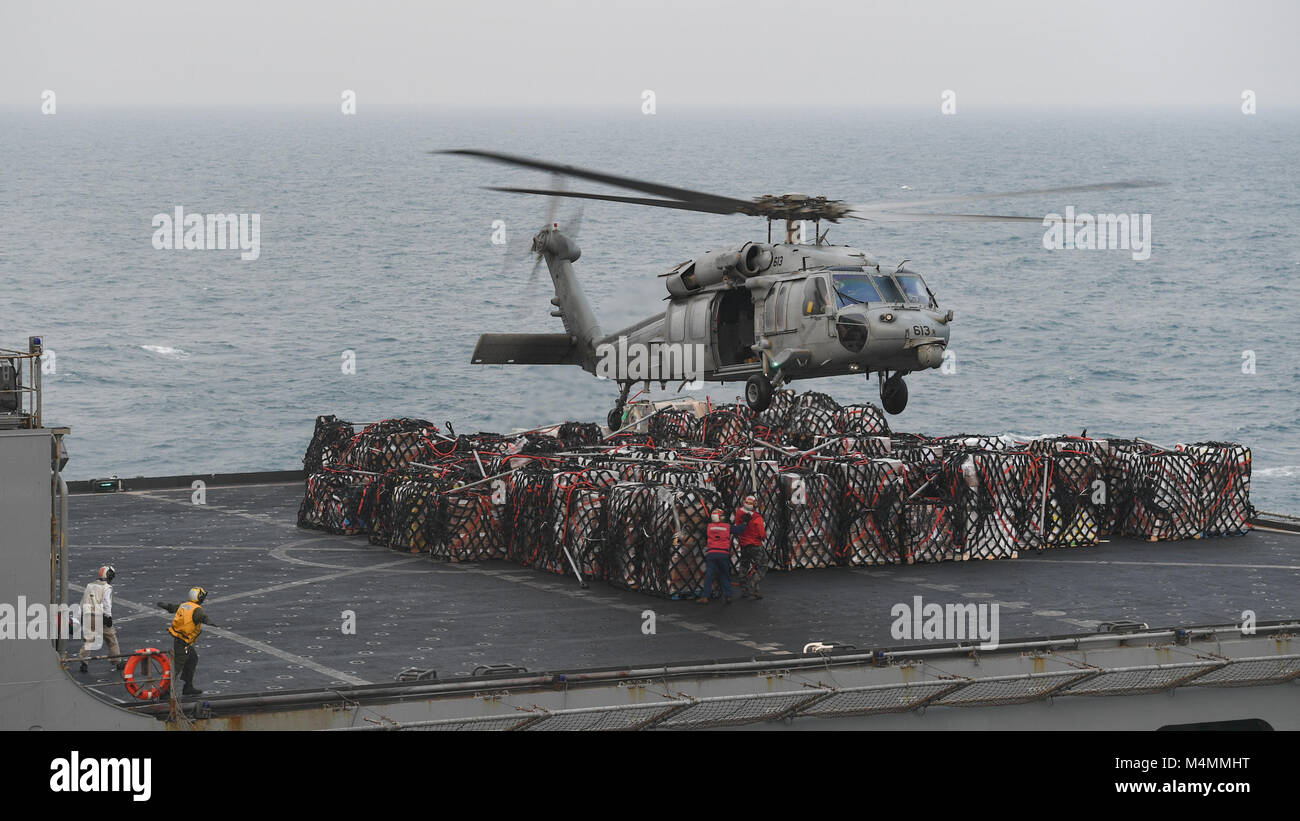 180215-N-AD499-1006 ARABIAN GULF (Feb. 15, 2018) An MH-60S Sea Hawk, assigned to the Indians of Helicopter Sea Combat Squadron (HSC) 6, retrieves cargo from the dry cargo and ammunition ship USNS Alan Shepard (T-AKE 3) during a replenishment-at-sea. Theodore Roosevelt and its carrier strike group are deployed to the U.S. 5th Fleet area of operations in support of maritime security operations to reassure allies and partners and preserve the freedom of navigation and the free flow of commerce in the region. (U.S. Navy photo by Mass Communication Specialist 3rd Class Victoria Foley/Released) Stock Photo