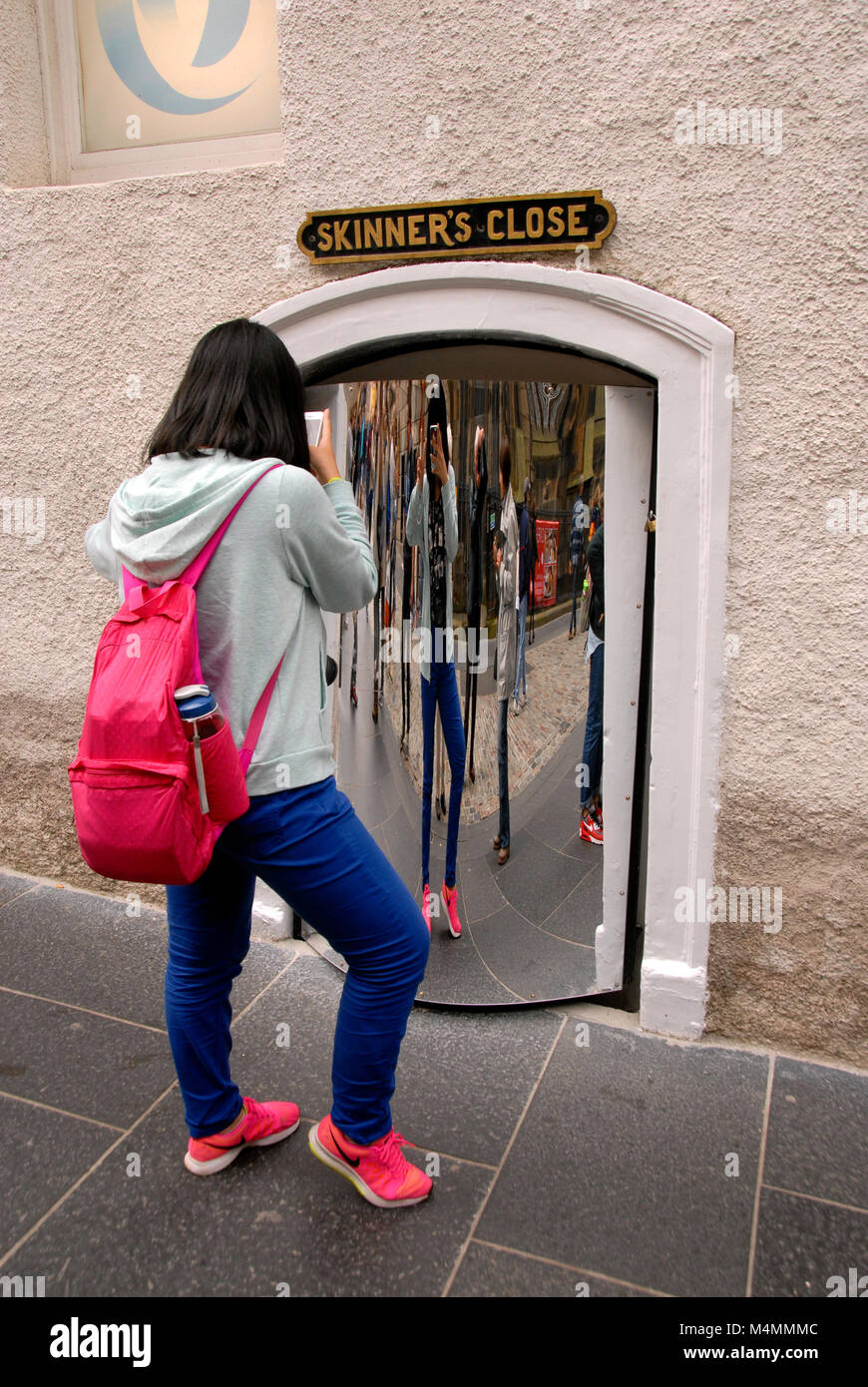 Young woman taking photograph of herself in a distorting mirror, Edinburgh Stock Photo
