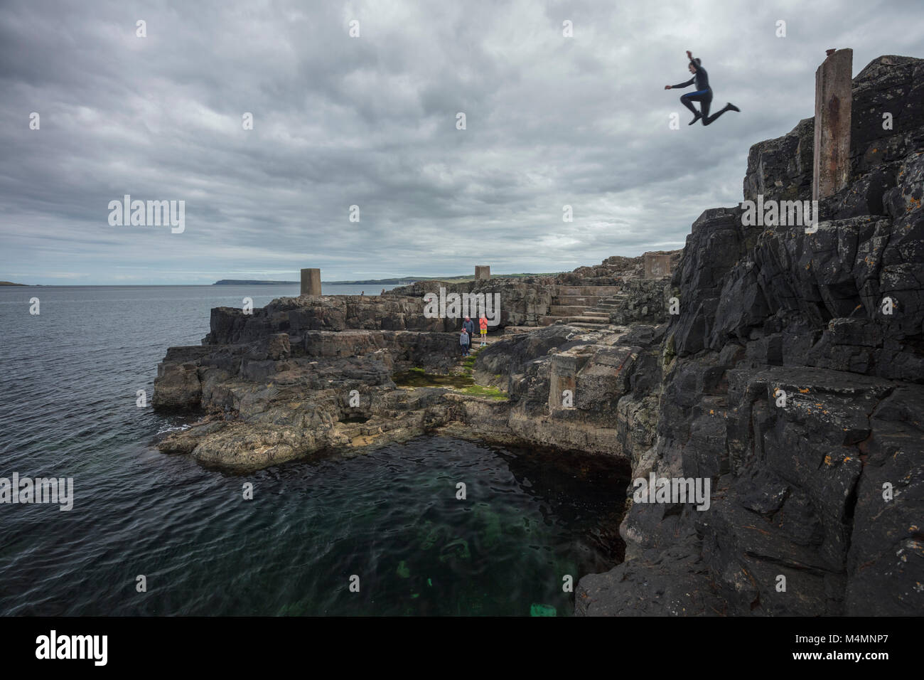 Cliff jumping into the Blue Pool, Portrush, County Antrim, Northern Ireland. Stock Photo