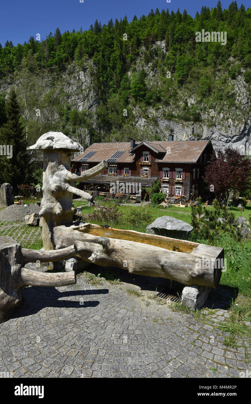 fountain in front of an old farmhouse; alps; Austria; Stock Photo