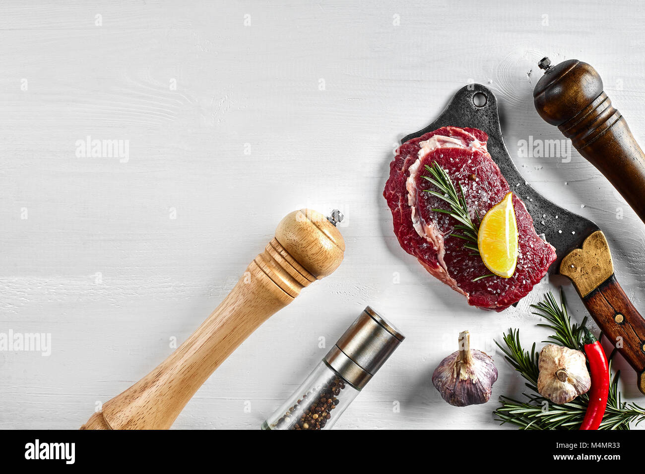 Fresh raw steaks with herbs, garlic, olive oil, pepper, salt, rosemary