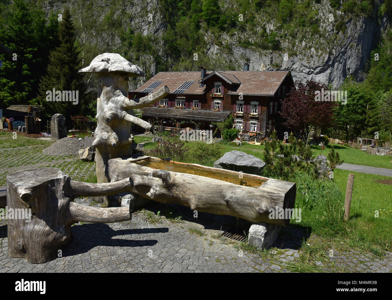 fountain in front of an old farmhouse; alps; Austria; Stock Photo