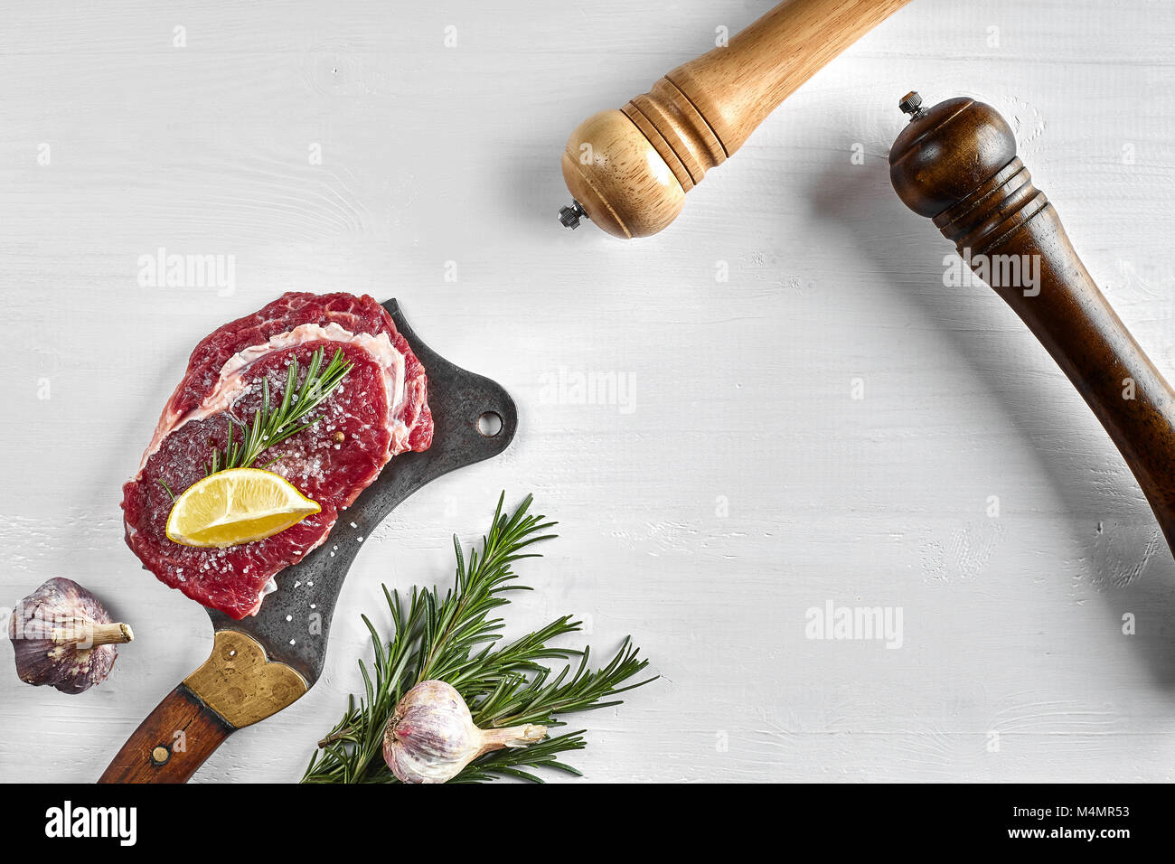 Fresh raw steaks with herbs, garlic, olive oil, pepper, salt, rosemary