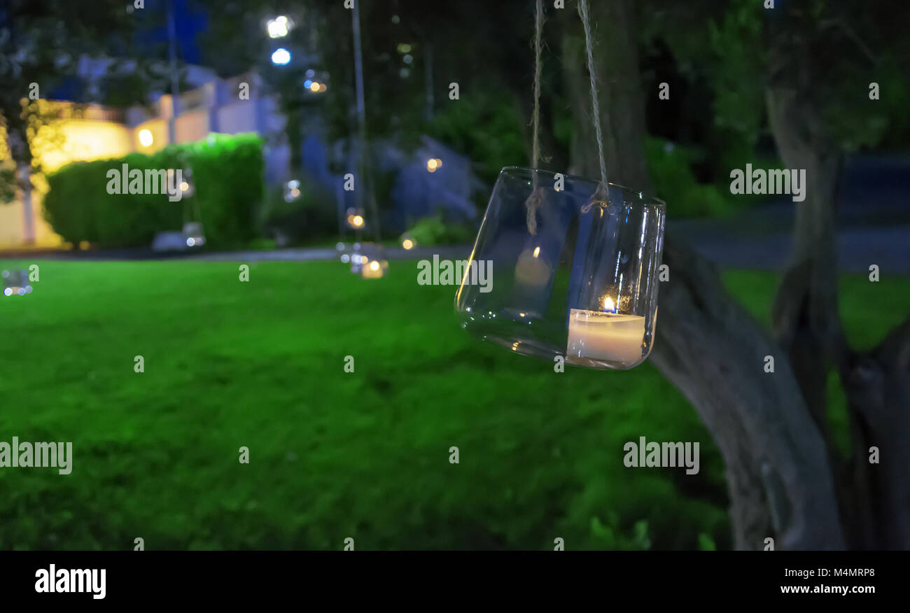 candle in a glass hanging from a tree Stock Photo Alamy