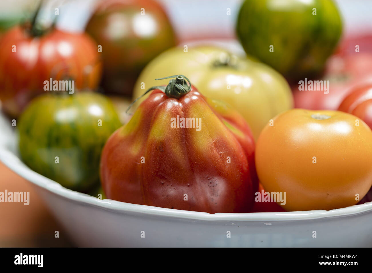 Heirloom Tomatoes in a white bowl Stock Photo Alamy