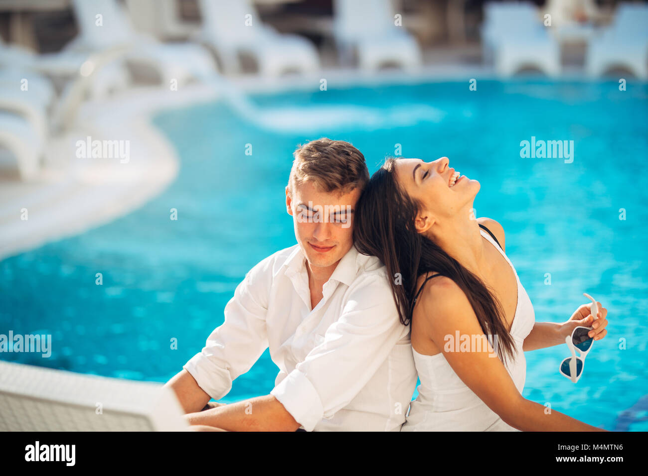 Cheerful happy couple enjoying spa vacation in luxurious summer resort.Honeymoon trip.Anniversary  celebration.Boyfriend and girlfriend having fun.Emo Stock Photo