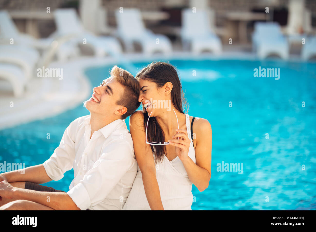 Cheerful happy couple enjoying spa vacation in luxurious summer resort.Honeymoon trip.Anniversary  celebration.Boyfriend and girlfriend having fun.Emo Stock Photo