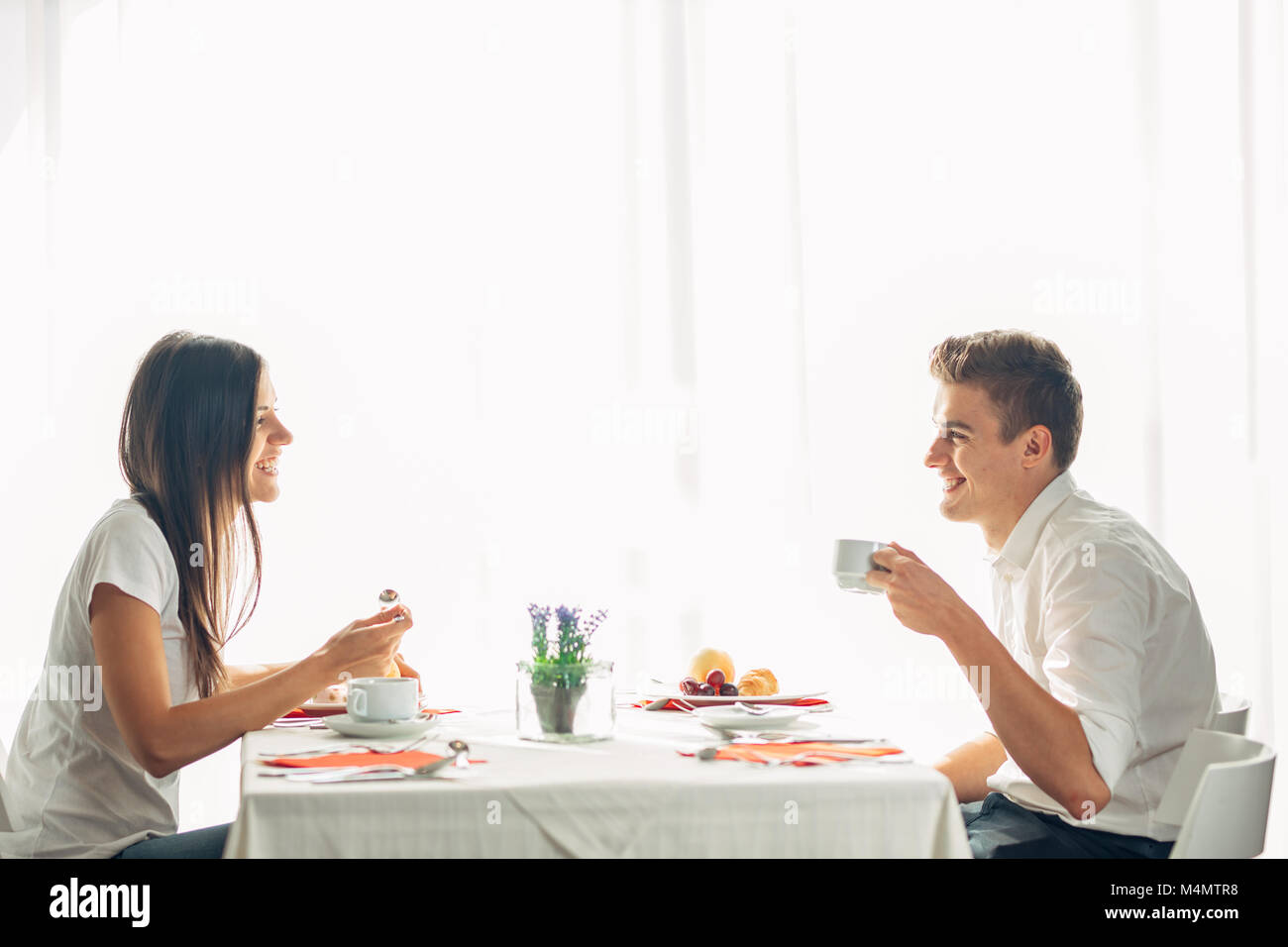 Happy couple at restaurant eating lunch.Talking over meal.Hotel full board,all inclusive stay.Travel, date,food,lifestyle.Smiling people having health Stock Photo