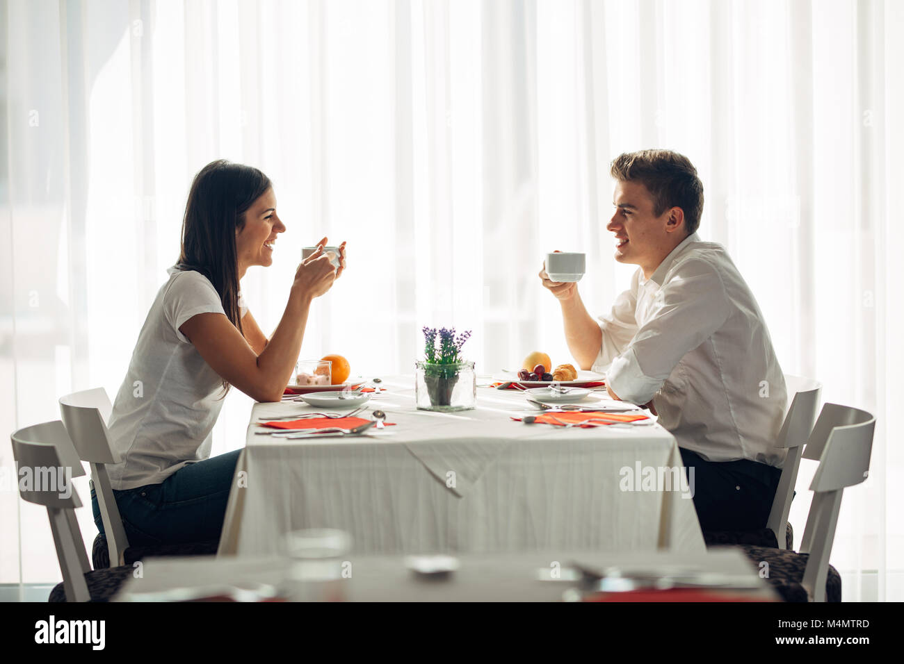 Happy couple at restaurant eating lunch.Talking over meal.Hotel full board,all inclusive stay.Travel, date,food,lifestyle.Smiling people having health Stock Photo
