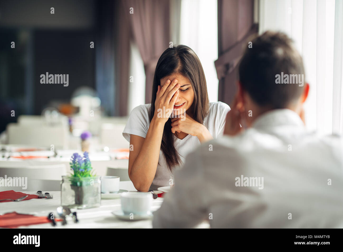 Crying stressed woman reaction to negative event,handling bad news.Breaking up long relationship.Emotional woman in grief,emotional pain.Couple fighti Stock Photo