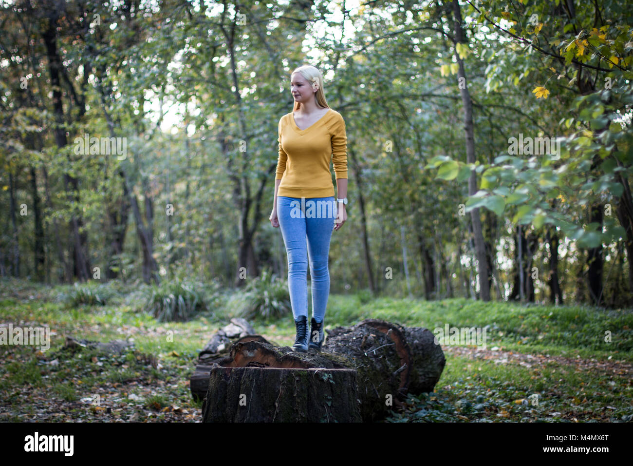 Young and beautiful blonde woman in the forest, enjoying nature. Stock Photo