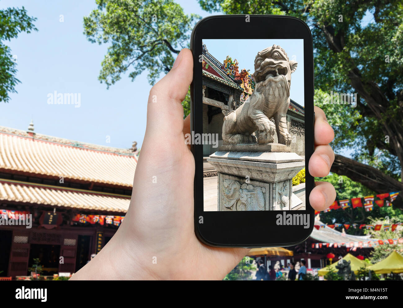 travel concept - tourist photographs outdoor lion statue in Guangxiao Buddhist Temple (Bright Obedience, Bright Filial Piety Temple) in Guangzhou city Stock Photo