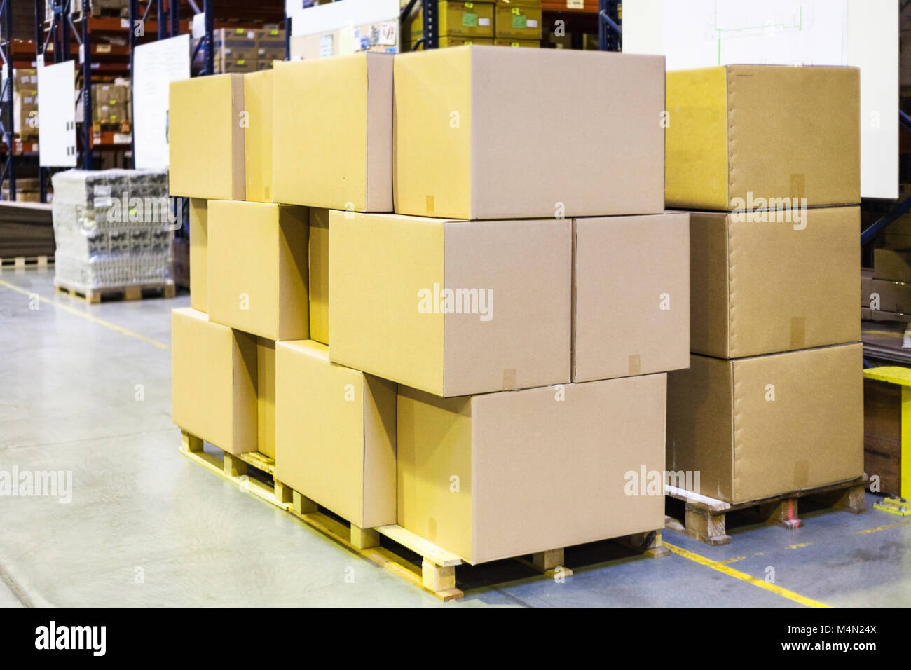 packaged boxes and cartons on wooden pallets in warehouse Stock Photo